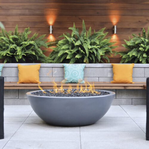 a fire pit with pillows and a bench