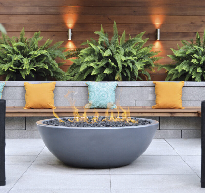 a fire pit with pillows and a bench