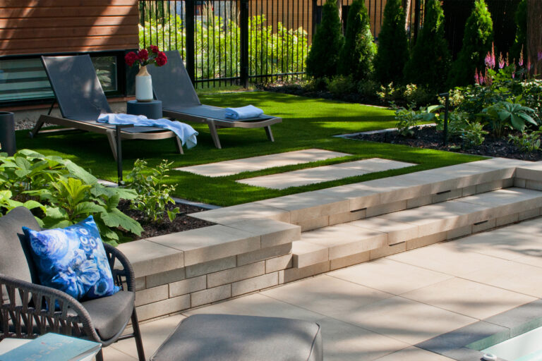 a lawn with chairs and a stone wall