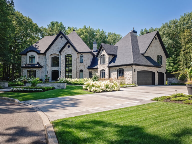 a large house with a driveway and trees in the background