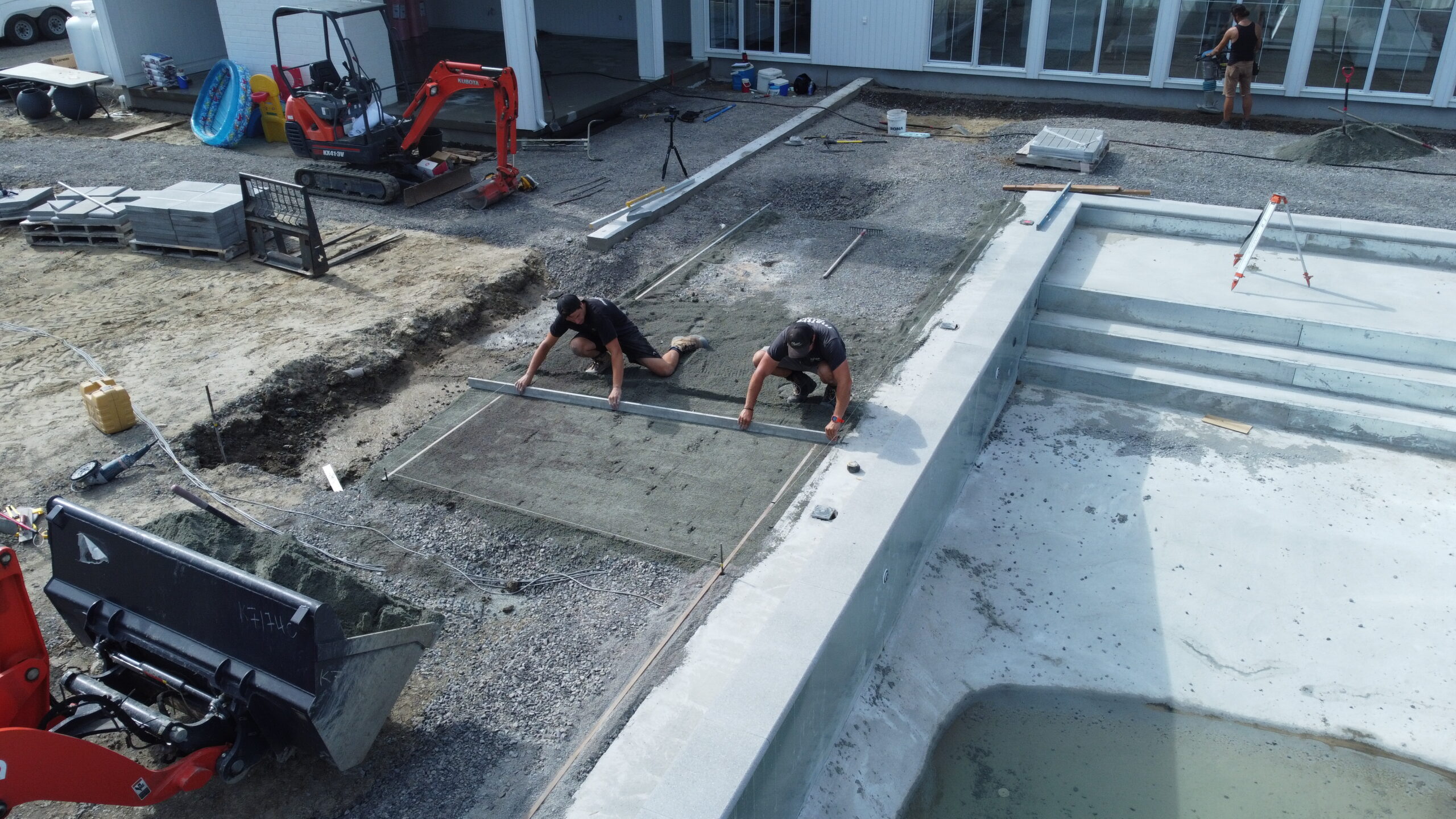 Travailleurs construisant une piscine extérieure.