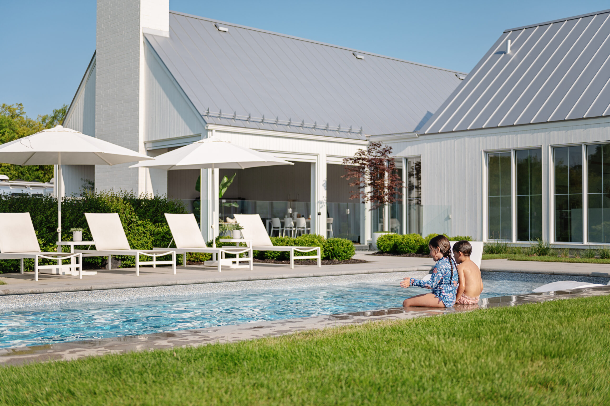Enfants près de la piscine ensoleillée.