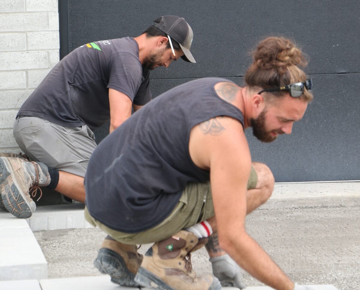 Deux hommes posant des pavés