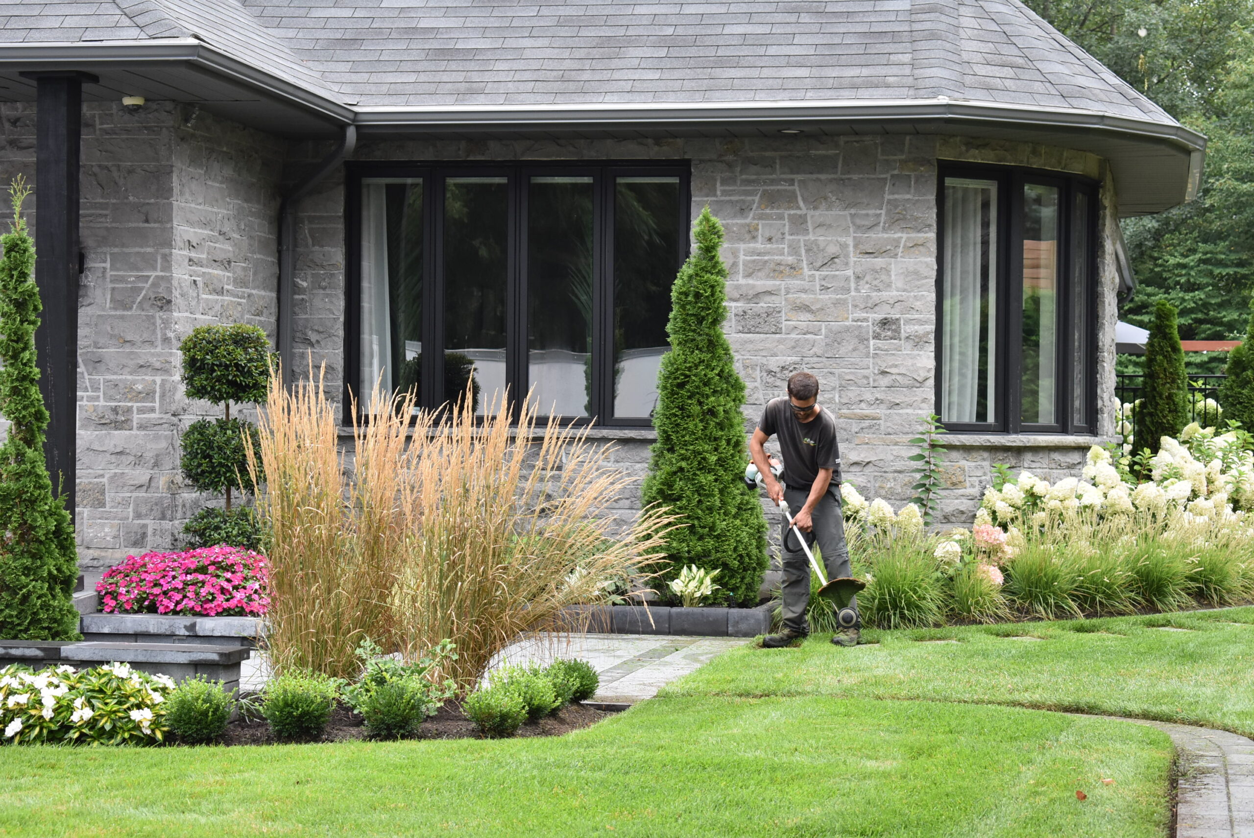 Jardinier travaillant devant une maison.