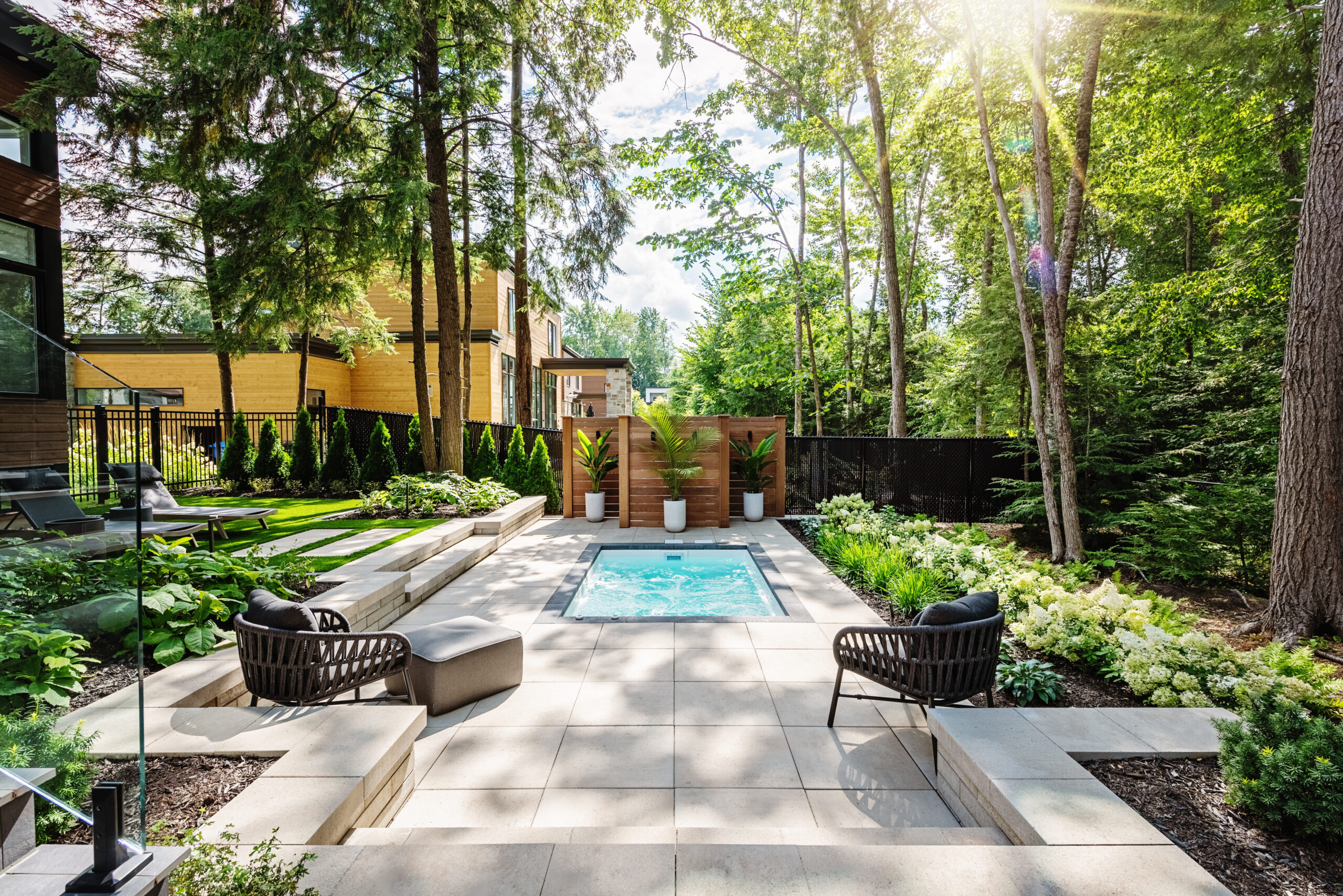 Jardin moderne avec piscine et chaises.